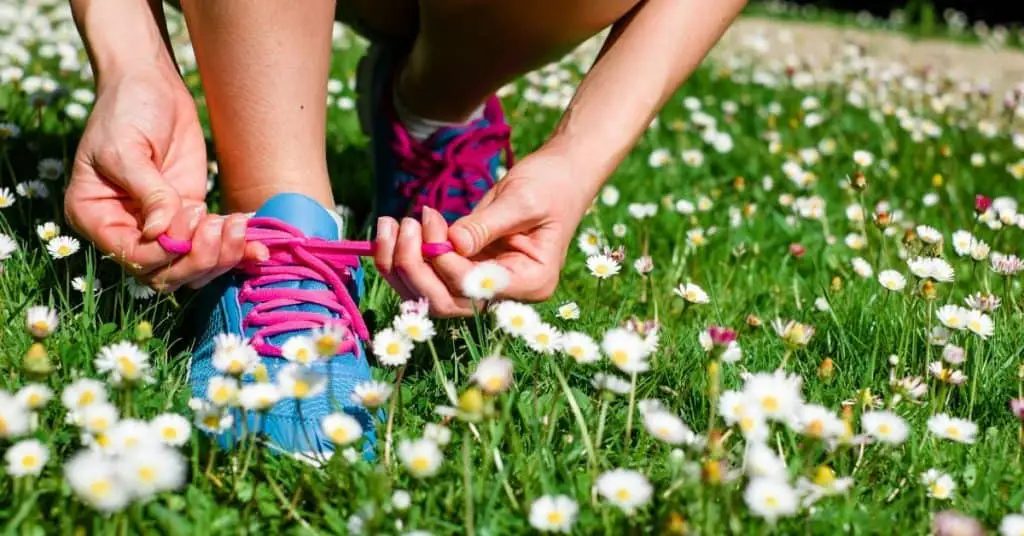 A woman doing up running shoes,