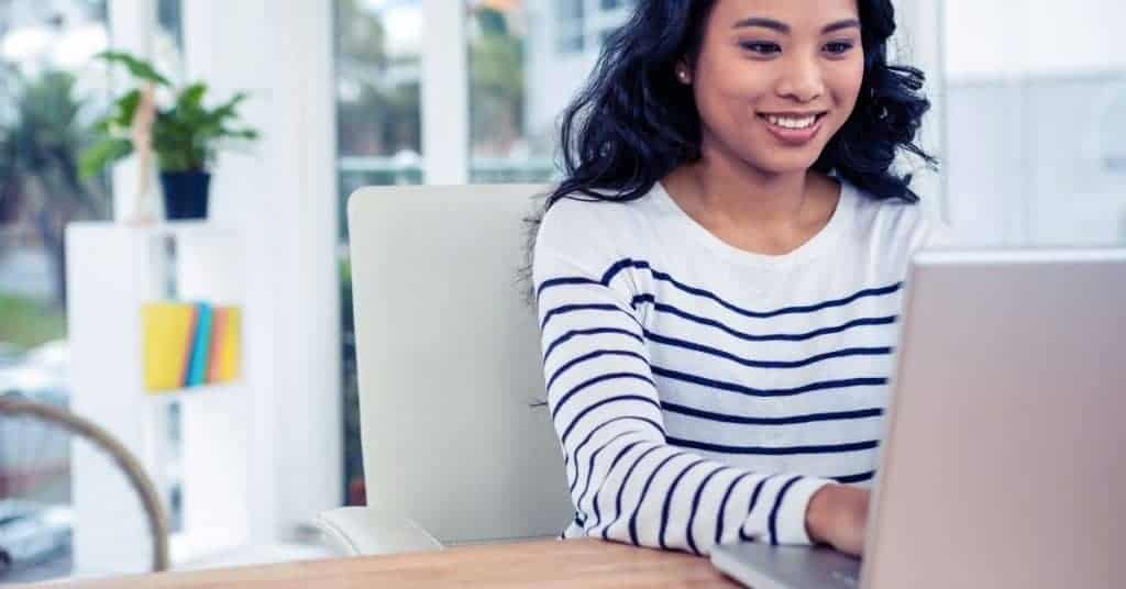 Woman checking her email at a designated time as a self care in the workplace strategy