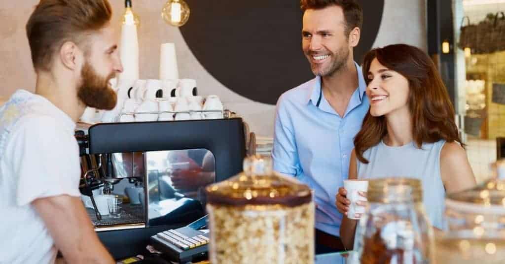 Man and woman ordering a coffee as part of their self care checklist.