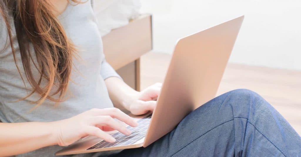 Woman assessing her teacher wellness using her laptop.