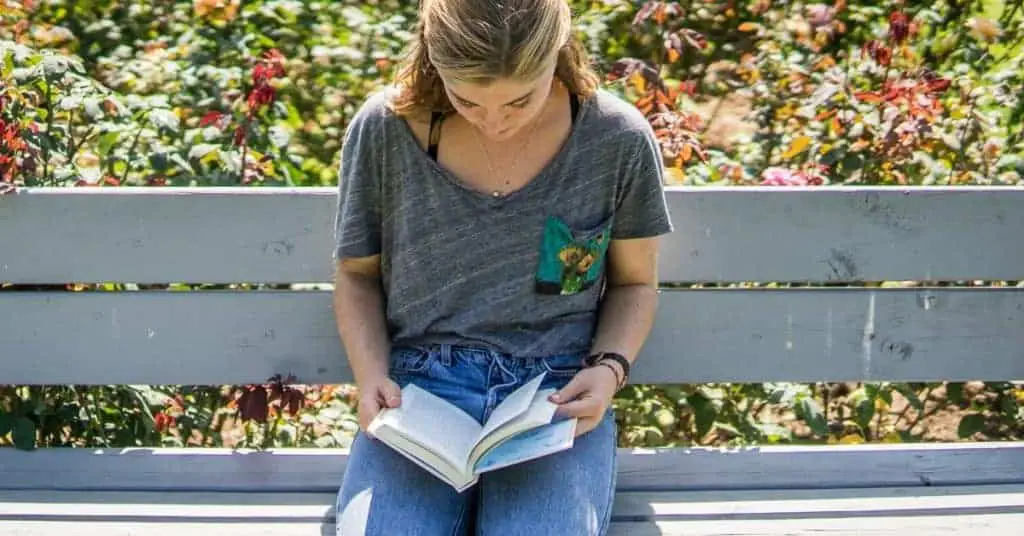 Woman reading a book as one of her self care checklist activities.