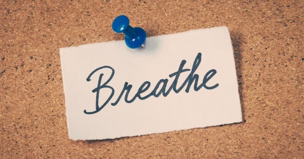 A pinboard with the word "breathe" tacked up on it,