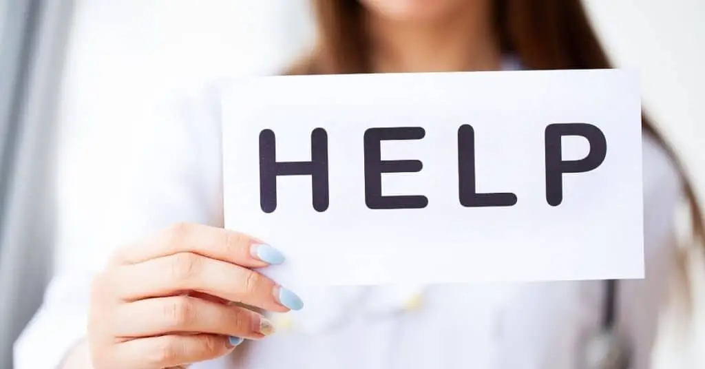 Woman holding a sign saying help.