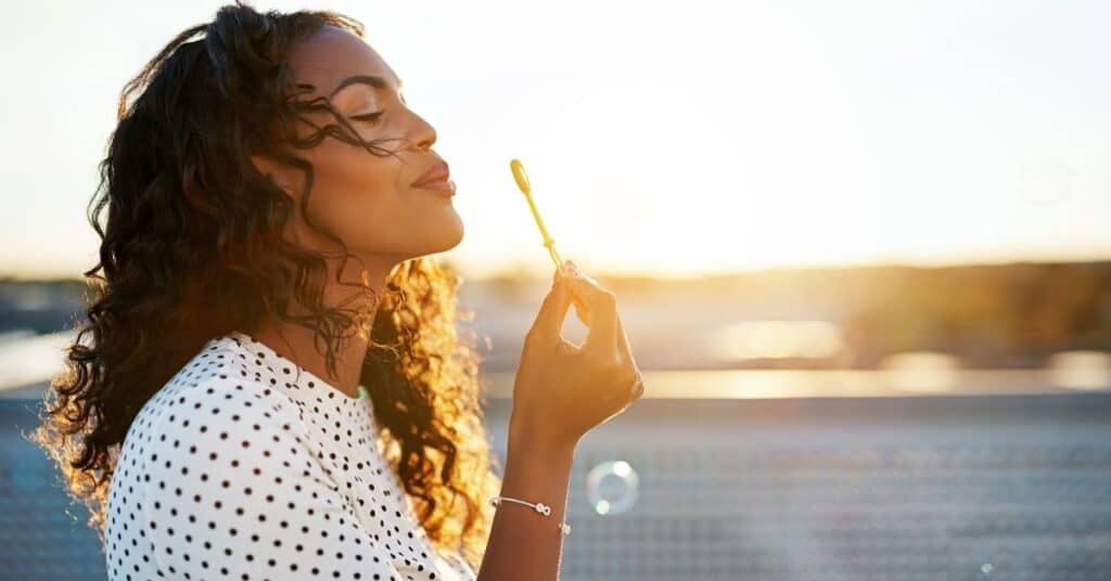 Woman being mindful blowing bubbles.