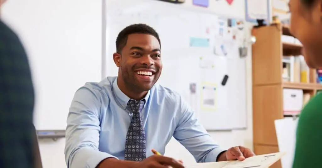 Happy looking black teacher in the classroom.