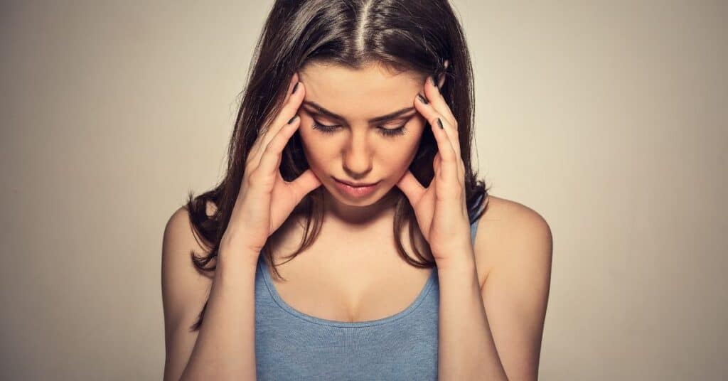 Woman looking stressed with her head in her hands.