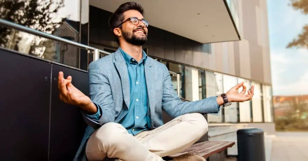 Man sitting on a bench practicing mindful listening.