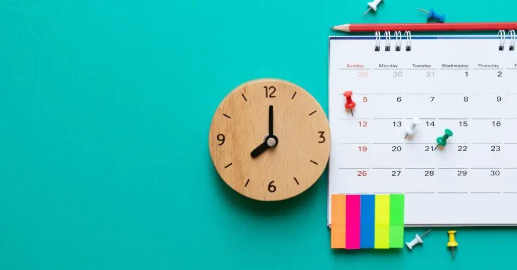 A calendar, clock and post its on a vibrant aqua background