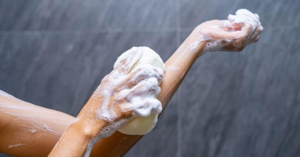 Woman soaping herself in the shower.