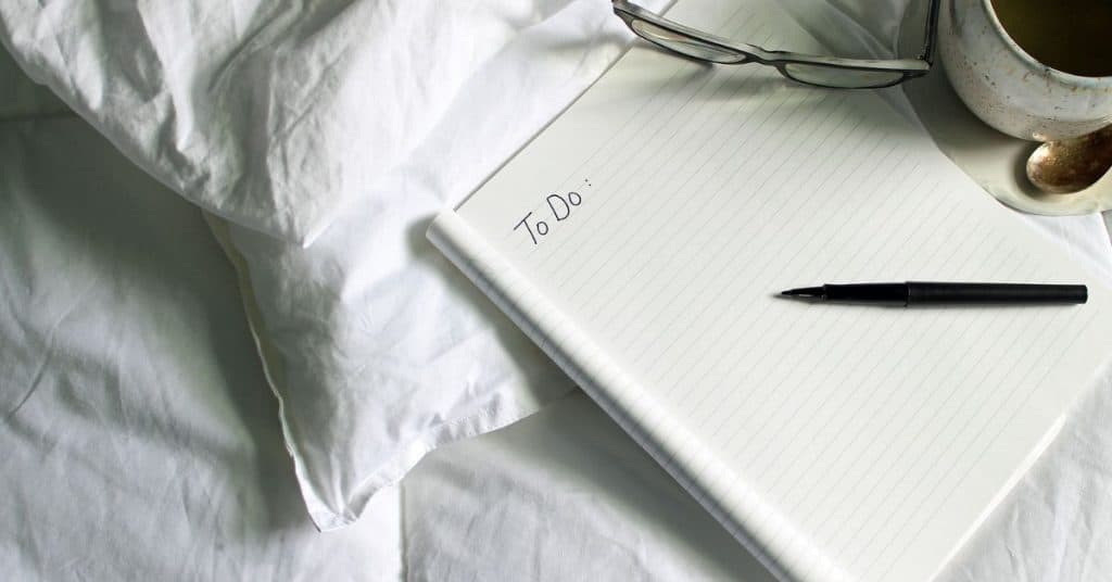 a notebook by the bed with to do written on it
