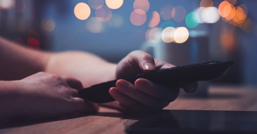 woman turning off computer to get ready for bedtime