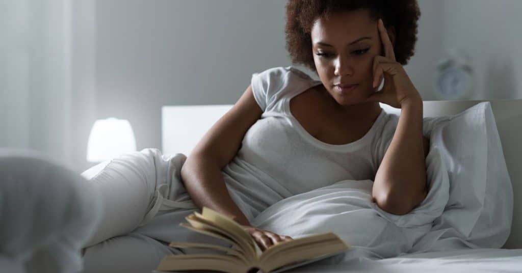 woman reading a book in bed